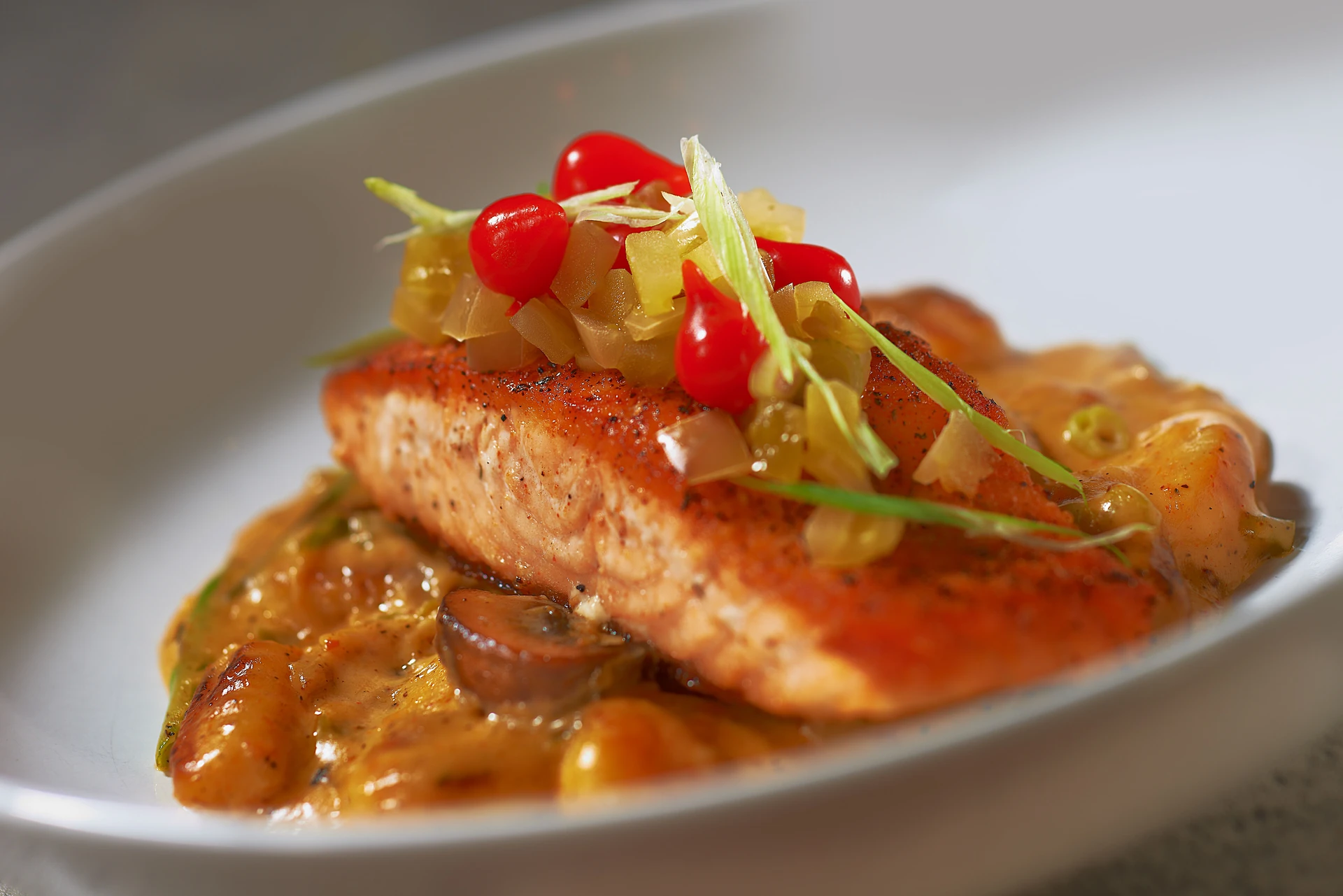 Seared Salmon Filet, Ricotta Gnocchi, Sautéed Mushrooms, Asparagus, Cajun Bechamel, and Pickled Green Tomato Relish